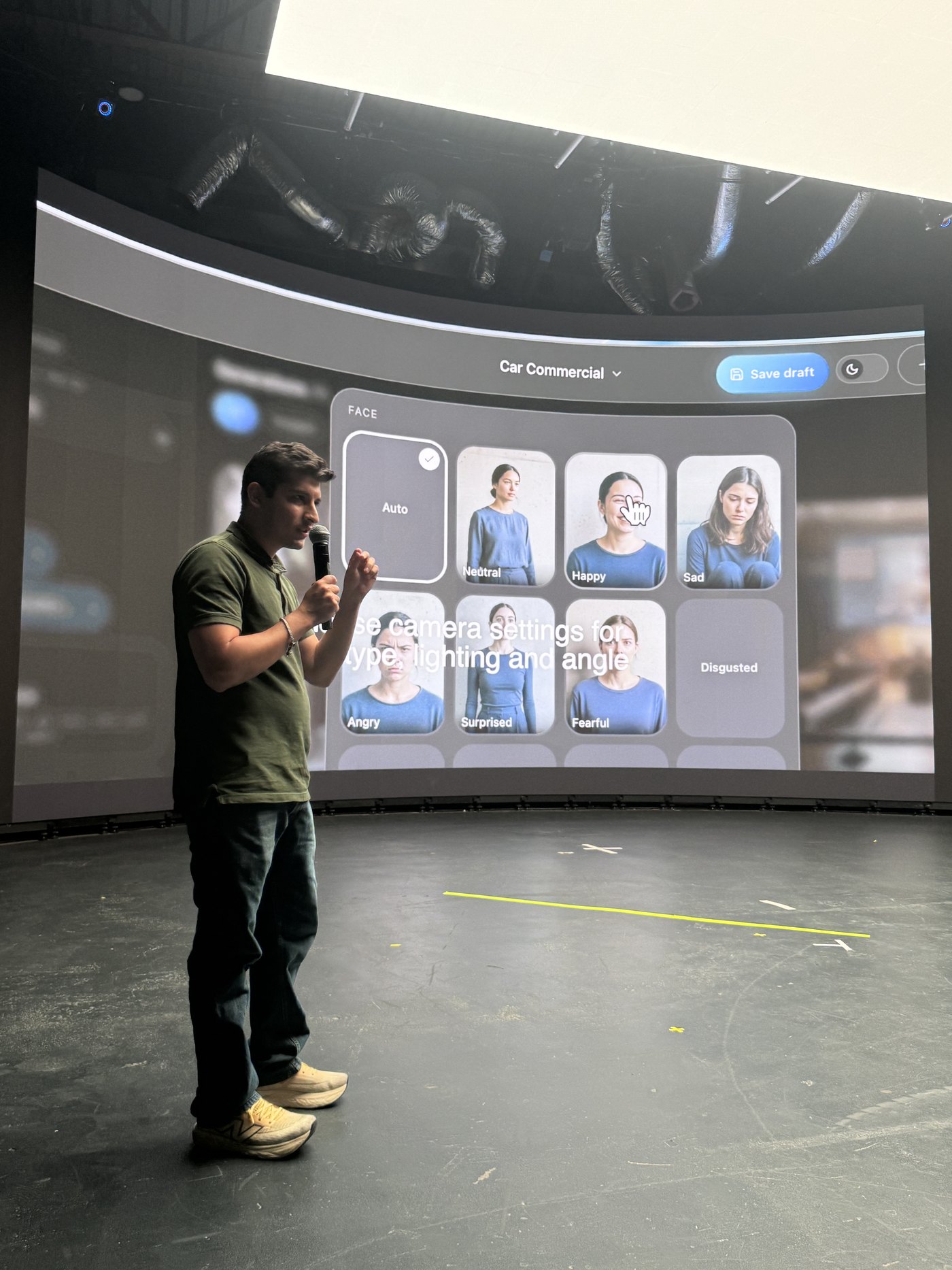 Javishth Chabria delivering a keynote in front of a projected grid of character expressions.